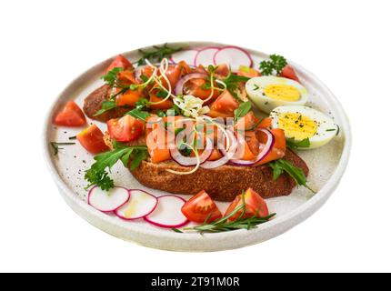 Toast mit geräuchertem Lachs, Zwiebeln und Gemüse auf einem weißen Teller in Nahaufnahme Stockfoto