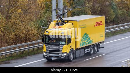 Wesenberg, Deutschland. November 2023. Ein vollelektrischer Oberleitungswagen des Logistikunternehmens DHL fährt auf der A1 E-Highway-Teststrecke zwischen Reinfeld und Lübeck. Hier wird der Stromabnehmer verlängert. Quelle: Markus Scholz/dpa/Alamy Live News Stockfoto