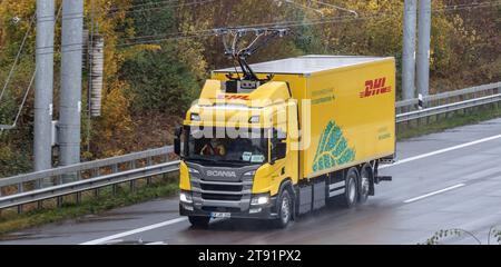 Wesenberg, Deutschland. November 2023. Ein vollelektrischer Oberleitungswagen des Logistikunternehmens DHL fährt auf der A1 E-Highway-Teststrecke zwischen Reinfeld und Lübeck. Hier wird der Stromabnehmer verlängert. Quelle: Markus Scholz/dpa/Alamy Live News Stockfoto