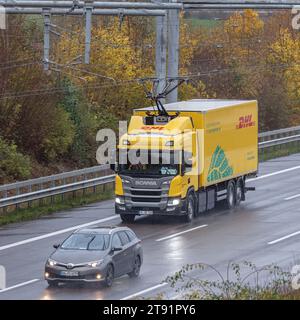 Wesenberg, Deutschland. November 2023. Ein vollelektrischer Oberleitungswagen des Logistikunternehmens DHL fährt auf der A1 E-Highway-Teststrecke zwischen Reinfeld und Lübeck. Hier wird der Stromabnehmer verlängert. Quelle: Markus Scholz/dpa/Alamy Live News Stockfoto