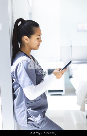 Birassische Ärztin mit Smartphon im Krankenhaus Stockfoto