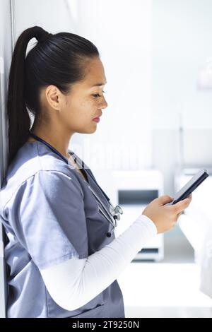 Birassische Ärztin mit Smartphon im Krankenhaus Stockfoto