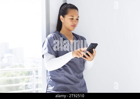 Birassische Ärztin mit Smartphon im Krankenhaus Stockfoto