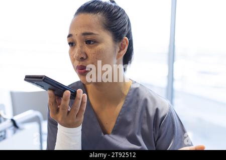 Birassische Ärztin, die im Krankenhaus auf dem Smartphone spricht Stockfoto