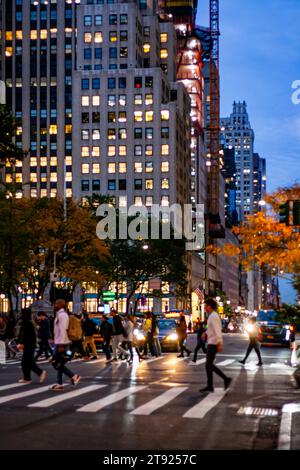 Fußgänger in Manhattan, New York City, überqueren die Straße an einem Herbstabend Stockfoto