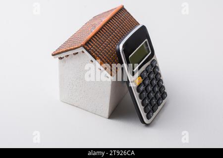 Modell Haus und Taschenrechner auf weißem Hintergrund Stockfoto
