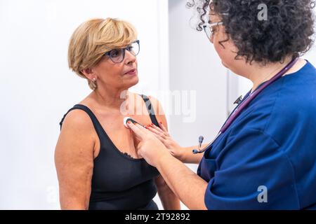 Ärztin, die eine Frau mit Herzproblemen einem EKG-Holter-Monitortest mit innovativem Gerät unterzieht Stockfoto