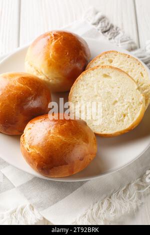 Hveteboller Norwegian Cardamom Brötchen weiche, nach Kardamom duftende Rollen in Nahaufnahme auf dem Teller auf dem Tisch. Vertikal Stockfoto