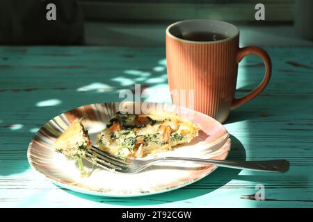 Köstlicher Quiche-Kuchen mit Lachsfischen und Pinienkerne-Füllung. Frühstück mit Quiche und einer Tasse Kaffee Stockfoto