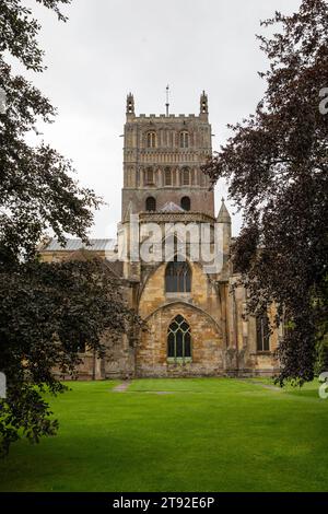 Eine Seitenhöhe der Abbey Church of St Mary the Virgin, besser bekannt als Tewksbury Abbey, eingerahmt von Bäumen Stockfoto