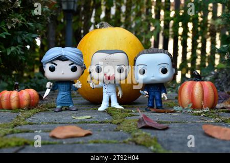 Funko Pop Actionfiguren der Horrorfiguren Norman Bates, Hannibal Lecter und Michael Myers. Halloween, gruselige Saison, Kürbisse, Moos, Blätter. Stockfoto