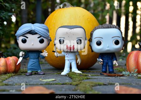 Funko Pop Actionfiguren der Horrorfiguren Norman Bates, Hannibal Lecter und Michael Myers. Halloween, gruselige Saison, Kürbisse, Moos, Blätter. Stockfoto