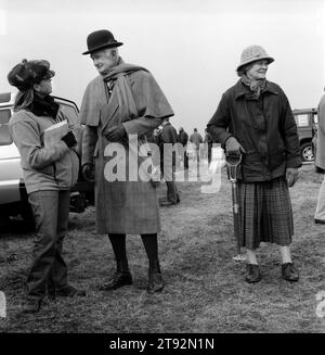 Hase Coursing 2002 UK. Der Waterloo Cup, eine dreitägige Veranstaltung, findet seit 1836 in der Nähe von Altcar statt. Modisch gekleideter Mann mit Bowler Hut und cape, mit Vieren, die nicht so gut waren, dass die Frau ihren Schießstock trug. Lancashire, England. 2002 HOMER SYKES Stockfoto