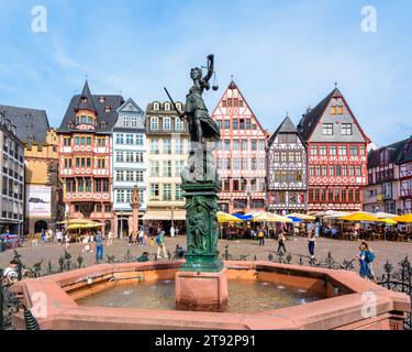 Statue und Springbrunnen der Gerechtigkeit auf dem Römerberg in der Frankfurter Altstadt, gesäumt von Straßencafés und Fachwerkhäusern. Stockfoto