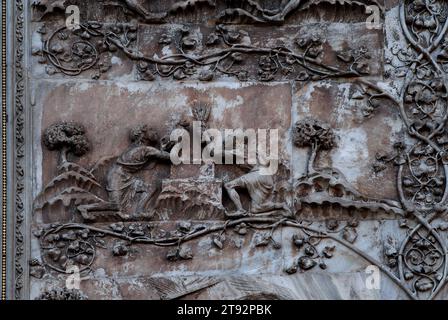 Kain und Abel opfern Gott, eine Weizengarbe von Kain und ein Lamm von Abel. Marmorrelief an der Westfront der Kathedrale in Orvieto, Umbrien, Italien, Duomo di Santa Maria Assunta. Diese Skulptur wird Lorenzo Maitani (ca. 1275–1330) zugeschrieben, der die spätgotische Fassade der Kathedrale entwarf. Maitani soll als Bildhauer direkt auf zwei Tafeln eingegangen sein, die zwei der vier unteren Pilaster der Fassade bedecken: Eine Platte zeigt Szenen aus der hebräischen Bibel/dem Alten Testament, einschließlich der Szene in diesem Bild. Stockfoto