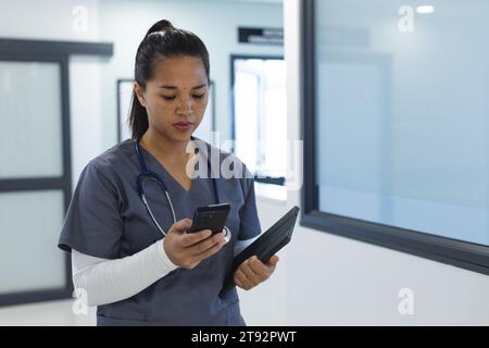 Birassische Ärztin mit Handschuhen im Krankenhauskorridor Stockfoto