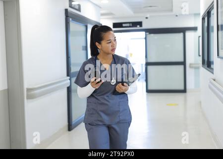 Birassische Ärztin mit Handschuhen im Krankenhauskorridor Stockfoto