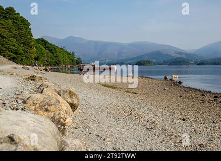 Menschen Touristen Besucher am Seeufer der High Brandelhow Bay Derwentwater im Sommer Lake District National Park Cumbria England Großbritannien Stockfoto