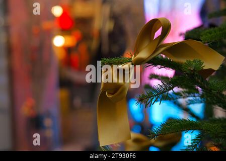 Mit diesem faszinierenden Bild mit einem goldenen Stoffband auf einem Tannenbaum-Zweig verschönern Sie Ihre Weihnachtseinkäufe und Weihnachtseinkäufe. Das b Stockfoto