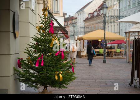 Tauchen Sie ein in die festliche Atmosphäre eines Weihnachtsbaums mit goldenen und rosa Bändern, der elegant im linken Drittel der ima positioniert ist Stockfoto