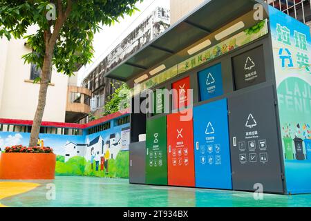 Zhongshan China-10.Oktober 2023: Abfalltonnen in verschiedenen Farben für die Müllsortierung, d. h. Küche, schädliche, andere und recycelbare Abfälle. In einem Garten bei Hor Stockfoto