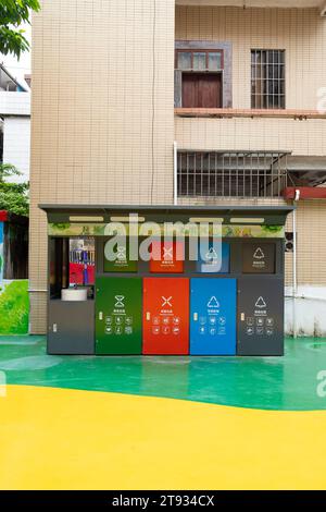 Zhongshan China-10.Oktober 2023: Abfalltonnen in verschiedenen Farben für die Müllsortierung, d. h. Küche, schädliche, andere und recycelbare Abfälle. In einem Garten auf ver Stockfoto
