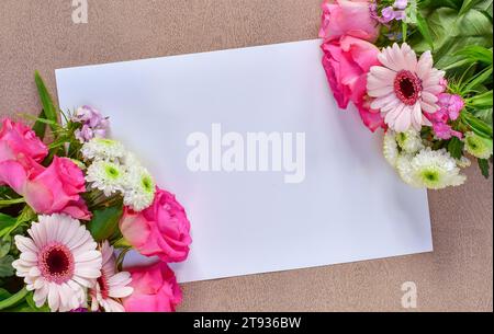 Schöner rosa Blumenstrauß an der Ecke eines leeren weißen Grußkartenpapiers mit Platz für Text. Flache Karte zum Geburtstag, Glückwunsch Stockfoto