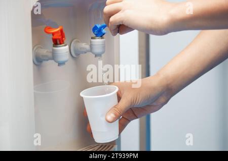 Mann Füllung Plastikbecher am Wasserkühler Stockfoto