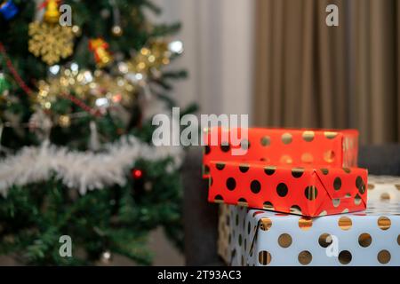 Frau Hand mit weihnachtsgeschenken und weihnachtsbaumhintergrund. Stockfoto