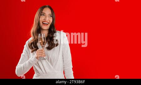 Die Dame toast fröhlich mit Weinglas auf rotem Studiohintergrund Stockfoto