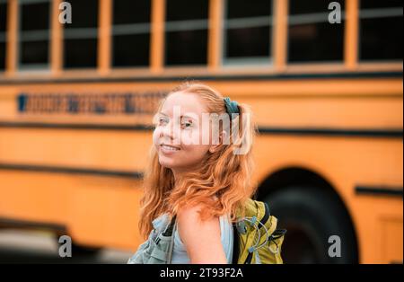 Glückliches Mädchen auf Schulbus aufgeregt für den ersten Tag der Schule. Fröhliche Schule Teenager. Bildung. Stockfoto