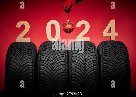 Winterreifen und Mann Hand in roten Handschuhen halten weihnachtsbaumkugel, 2024 Happy New Year Hintergrund. Stockfoto