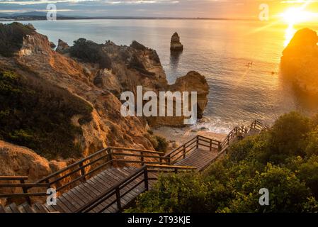 Holzsteg zum wunderschönen Strand Praia do Camilo in der Nähe von Lagos in Portugal bei Sonnenaufgang Stockfoto