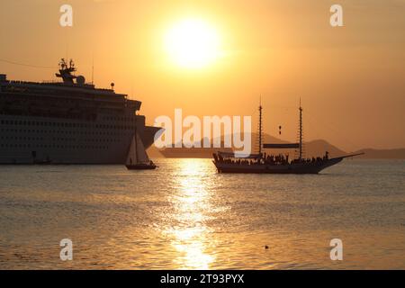 Transatlantische Abfahrt vom Hafen von Santos, Brasilien, neben einem Segelboot und einem Schoner bei Sonnenuntergang Stockfoto