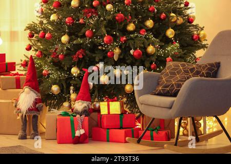 Wunderschön verpackte Geschenke unter dem Weihnachtsbaum im Zimmer. Festliche Inneneinrichtung Stockfoto