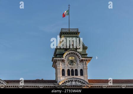 TRIEST, ITALIEN – 19. November 2023: Uhrenturm mit italienischer Flagge auf dem Rathaus von Triest, Platz der Einheit Italiens ( Piazza Unità d'Italia ) Stockfoto