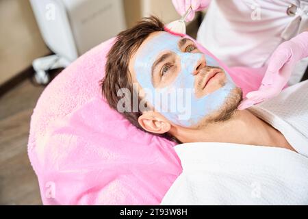 Der Mann liegt auf einer bequemen Couch in einem Kosmetikbüro Stockfoto