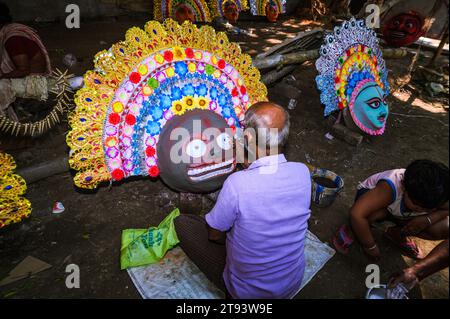 Ein Dorfidol-Künstler stellt große Farbmasken her, die Purulia Chhau Tanzmasken nachempfunden sind (Purulia Chhau Tanz ist auf der UNESCO-Liste der Tänze aufgeführt) von Göttinnen, Tieren und Rakshasas (humanoide Dämonen oder ungerechte Geister) wie hinduistische Mythologie-Charaktere aus Ton. Der Künstler malt dann die Götzenbilder mit Farbe, um sie in einem Jagaddhatri Puja Pandal zu installieren. Tehatta, Westbengalen, Indien. Stockfoto