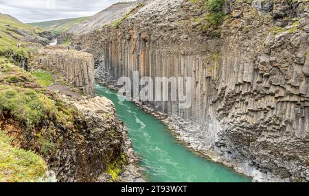 Der Jokla River durchschneidet den Studlagil Canyon und passiert die sechseckigen Basaltsäulen, die durch Lavaflüsse im Nordosten Islands verursacht wurden, Jokuldalur Valley, Stockfoto