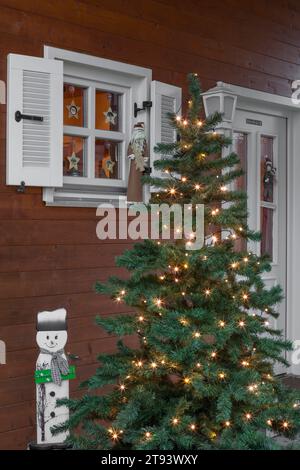 Geschmückter weihnachtsbaum, draußen vor einem Holzhaus Stockfoto