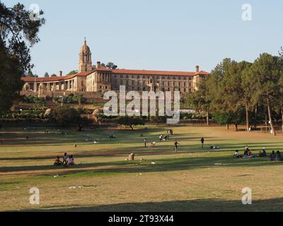 Union Buildings in Pretoria mit vielen Leuten, die sich im großen Stadtpark vor der Tür entspannen. Pretoria, Gauteng, Südafrika. Stockfoto