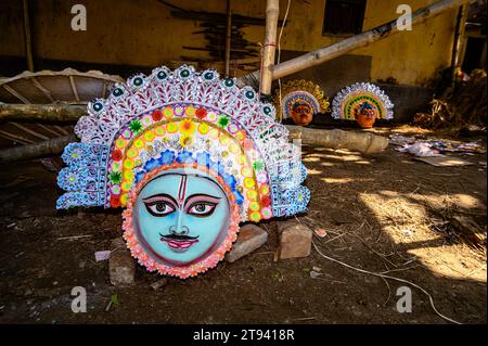 Ein Dorfidol-Künstler stellt große Farbmasken her, die Purulia Chhau Tanzmasken nachempfunden sind (Purulia Chhau Tanz ist auf der UNESCO-Liste der Tänze aufgeführt) von Göttinnen, Tieren und Rakshasas (humanoide Dämonen oder ungerechte Geister) wie hinduistische Mythologie-Charaktere aus Ton. Der Künstler malt dann die Götzenbilder mit Farbe, um sie in einem Jagaddhatri Puja Pandal zu installieren. Tehatta, Westbengalen, Indien. Stockfoto