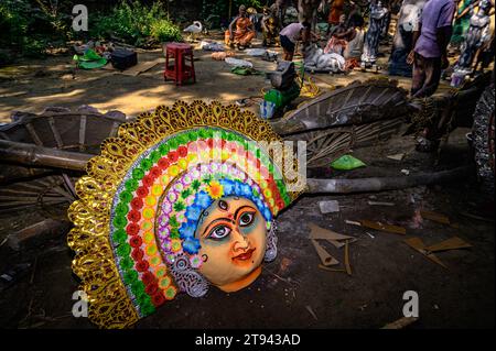 Ein Dorfidol-Künstler stellt große Farbmasken her, die Purulia Chhau Tanzmasken nachempfunden sind (Purulia Chhau Tanz ist auf der UNESCO-Liste der Tänze aufgeführt) von Göttinnen, Tieren und Rakshasas (humanoide Dämonen oder ungerechte Geister) wie hinduistische Mythologie-Charaktere aus Ton. Der Künstler malt dann die Götzenbilder mit Farbe, um sie in einem Jagaddhatri Puja Pandal zu installieren. Tehatta, Westbengalen, Indien. Stockfoto