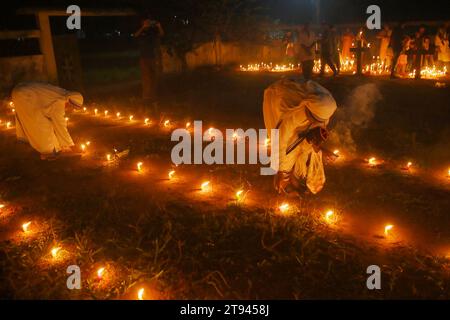 Nonnen beten neben den Gräbern ihrer Familienmitglieder auf einem Friedhof während des „All Souls Day“ am Stadtrand von Agartala. Tripura, Indien. Stockfoto