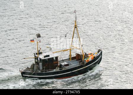 Ein kleines Fischerboot kehrt bei regnerischem Wetter zum Hafen zurück Stockfoto