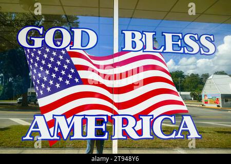 God Bless America Schild und Flagge am Fenster eines lokalen Ladens in einer kleinen Stadt in Nord-Florida. Stockfoto