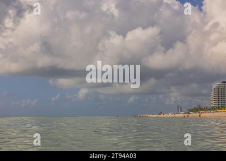 Atemberaubende Aussicht auf Miami Beach, wo die Menschen ihre Freizeit an den Sandstränden des Atlantischen Ozeans vor dem Hintergrund des Himmels genießen Stockfoto