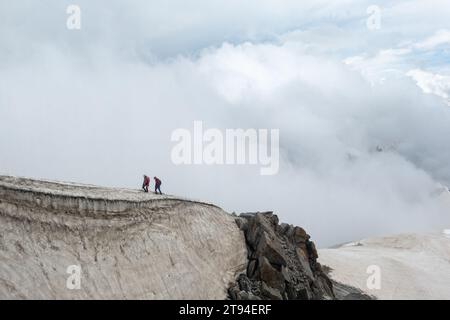 Chamonix, Frankreich - 25. August 2023: 2 Bergwanderer überqueren den Kamm, der bis zur Aiguille du Midi auf dem Gletscher des Mont Blanc-Massivs im Va führt Stockfoto
