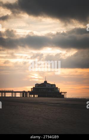 Sonnenuntergang an den Sandstränden von Oostende, Westbelgien. Die letzten Sonnenstrahlen brechen durch die Wolken. Rot-orange Hölle. Stockfoto