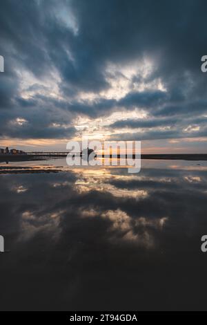 Sonnenuntergang an den Sandstränden von Oostende, Westbelgien. Die letzten Sonnenstrahlen brechen durch die Wolken. Rot-orange Hölle. Stockfoto